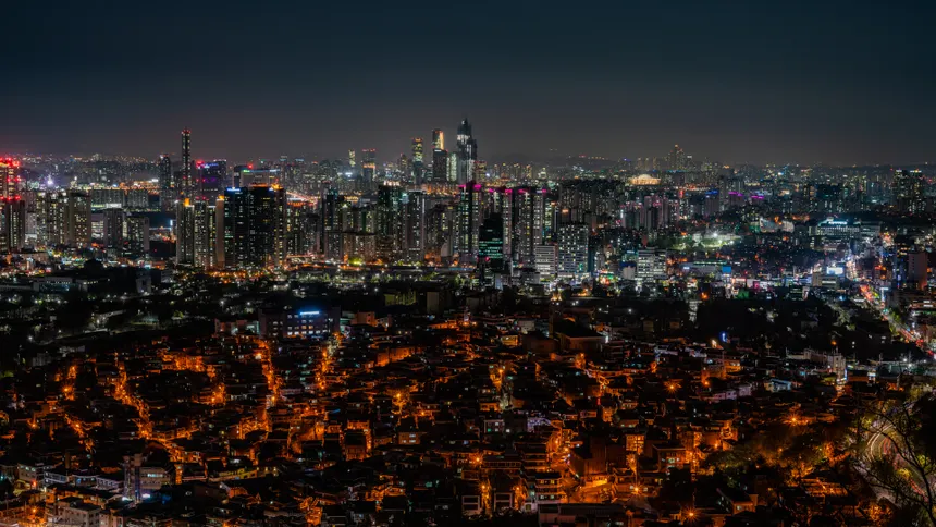 Stunning night view of Seoul's illuminated skyscrapers and bustling cityscape from above.