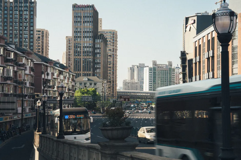 Dynamic city scene capturing buses and traffic amidst towering skyscrapers in daylight.