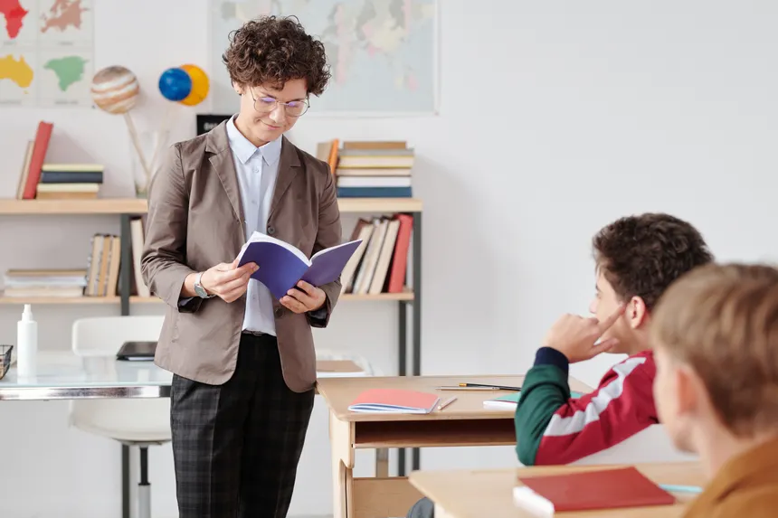 Teacher reading to students in a bright classroom setting, fostering an engaging learning environment.