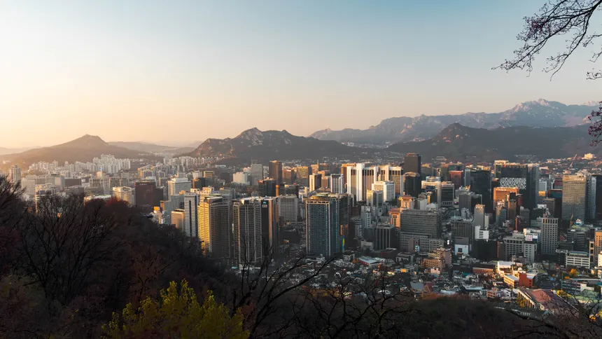 Stunning skyline view of Seoul from above at sunset, featuring Namsan Tower.